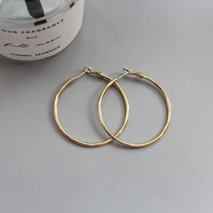 Macro view of minimalist 18K gold-plated hoop earrings with hook locking design