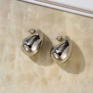 Detailed view of polished silver water drop stud earrings with high mirror reflection