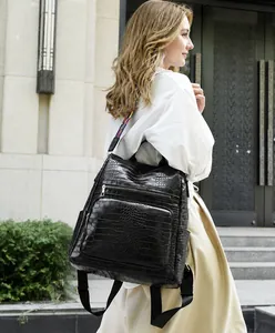 Detail of black anti-theft backpack with crocodile texture and colored woven strap