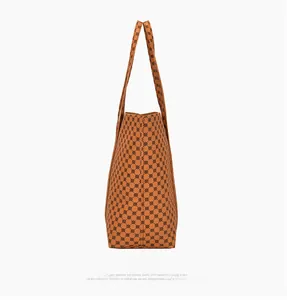 Vista laterale di una grande borsa tote marrone con stampa geometrica e tracolla regolabile