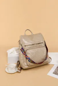Detail of beige faux crocodile texture backpack with bohemian patterned shoulder strap