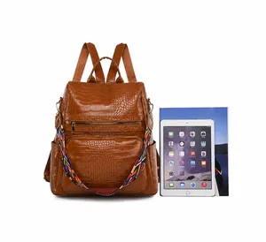 Brown crocodile pattern backpack shown with iPad and magazine to demonstrate large capacity