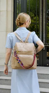Detail of beige faux leather backpack with crocodile texture and ethnic woven strap