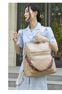 Close-up of beige crocodile textured PU leather backpack with colorful woven strap