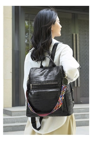 Detail of black crocodile texture backpack with colorful geometric strap for women