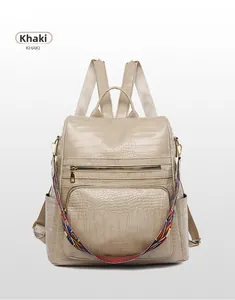 Detail of khaki anti-theft backpack with crocodile texture and colorful woven strap
