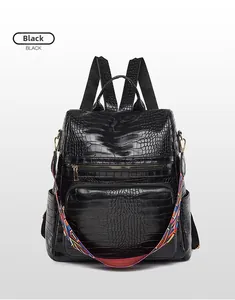 Detail of black crocodile texture backpack with colorful geometric woven shoulder strap