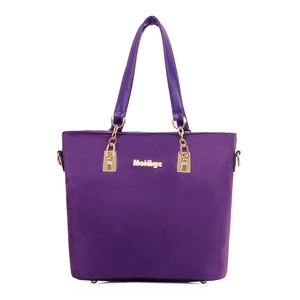 Purple nylon tote bag with gold chain handles and metallic brand logo on a white background