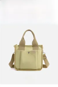 Detail of khaki canvas tote bag showing three front pockets and durable woven straps