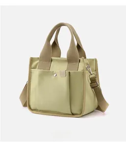 Detail of light green canvas tote with magnetic front pocket and adjustable shoulder strap