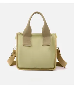 Detail of canvas tote bag with adjustable shoulder strap and reinforced woven handles