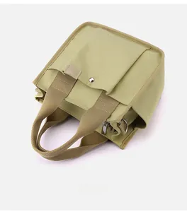 Detailed top view of grass green canvas tote with multiple pockets and sturdy zippers