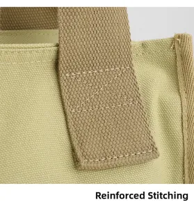 Close-up of reinforced X-shaped stitching on durable canvas tote bag shoulder straps