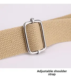 Macro detail of adjustable khaki canvas shoulder strap with silver metal buckle