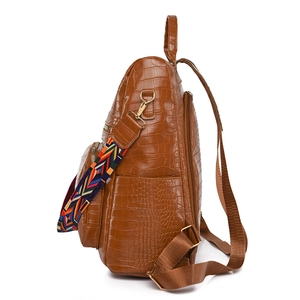 Brown faux leather anti-theft backpack for women with embossed texture and ethnic strap