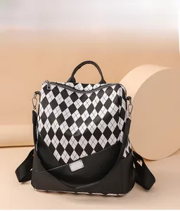 Detail of contrast color backpack with diamond lattice pattern and metallic brand plate