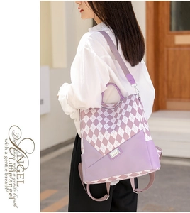 Detail view of the purple and white argyle backpack worn on shoulder with metal clasp