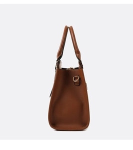 Side view of brown faux leather tote bag with trapezoidal structure and metal hardware