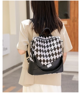 Fashionable black and white diamond lattice backpack shown from a street lifestyle perspective