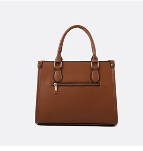 Detail view of the rear zipper pocket on a brown crocodile embossed leather tote bag