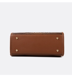 Macro detail of brown crocodile embossed bag bottom with golden metal protective feet