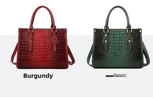 Detail view of crocodile textured tote bags in wine red and green with dual handles