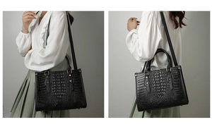 Detail of black crocodile embossed tote bag with metal rivets and detachable shoulder strap
