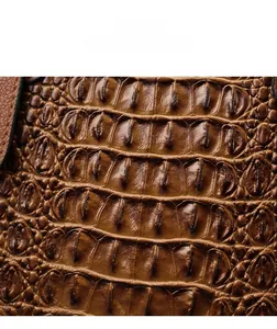 Close-up of brown crocodile embossed leather with a high-gloss finish and fine texture