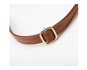 Detail of brown faux leather strap with adjustable gold metal buckle and neat stitching