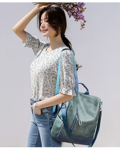 Outdoor shot of stylish contrast color PU leather backpack for women with blue bottom