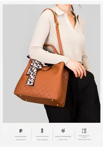 Détail du sac bandoulière marron gaufré avec foulard léopard et clous de fond dorés