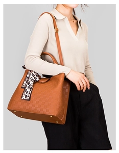 Sac cabas marron tressé avec foulard léopard porté à l'épaule par un mannequin