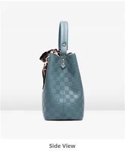 Détail latéral d'un sac à main bleu avec motif damier et foulard léopard en soie