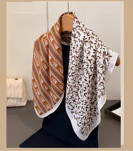 Detail of a lightweight scarf with geometric diamond and leaf patterns on a hanger