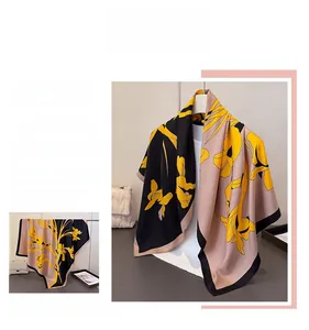 Macro detail of large floral print silk scarf featuring yellow flowers and black border