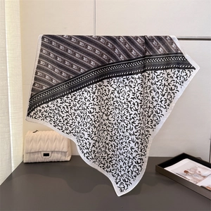 Detail of herringbone linen-feel square scarf hanging with elegant drape and leaf pattern