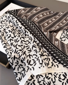 Close-up of black and white herringbone pattern scarf with bird motifs and textile texture