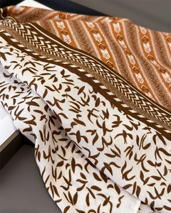 Detailed macro view of the herringbone pattern and elegant flying bird print on the scarf