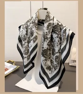 Detail view of retro floral pattern and black stripe border on beige silk-like scarf