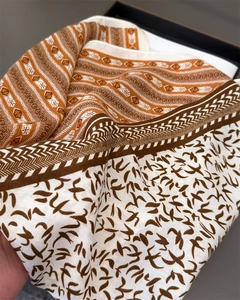 Detail of herringbone linen scarf featuring intricate swallow and geometric patterns