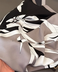 Macro shot of faux silk scarf featuring vintage floral patterns and smooth satin texture