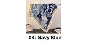 Détail d'un foulard carré bleu marine avec motifs floraux et bordures festonnées jaunes