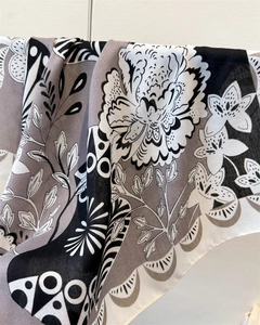 Détail d'un foulard en coton-lin à chevrons montrant l'imprimé floral et le drapé doux