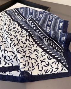 Detail of herringbone cotton linen scarf featuring blue swallows and geometric patterns