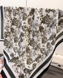 Detail of vintage floral pattern on large square silk feel scarf with black striped edges
