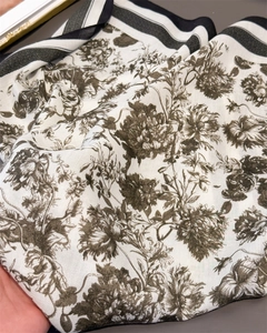 Detail of floral linen-feel scarf with olive patterns and striped border edges
