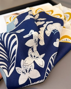 Détail du tissage en chevrons et des motifs de lys sur le foulard en soie bleu marine