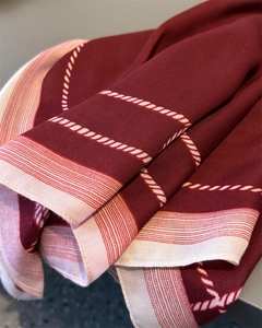 Detailed macro view of herringbone texture and white rope pattern on wine red silk scarf