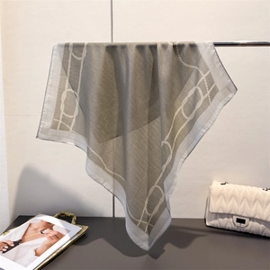 Minimalist grey silk scarf with white rope pattern elegantly draped on a metal bar