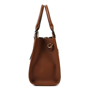 Side profile of brown crocodile texture handbag with gold D-ring hardware and shoulder strap